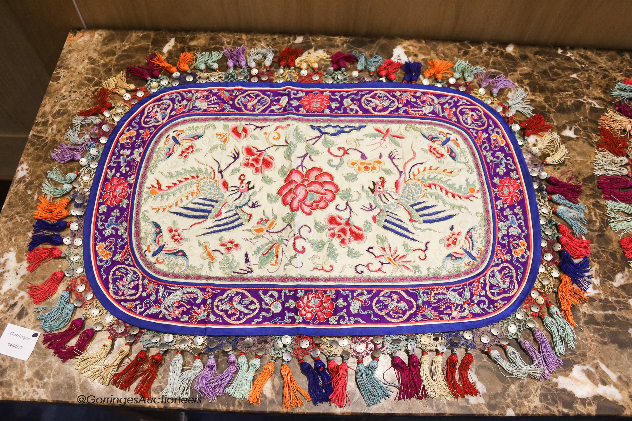 Four 20th century silk embroidered oval table centres edged with multi-coloured tassels, length 96cm